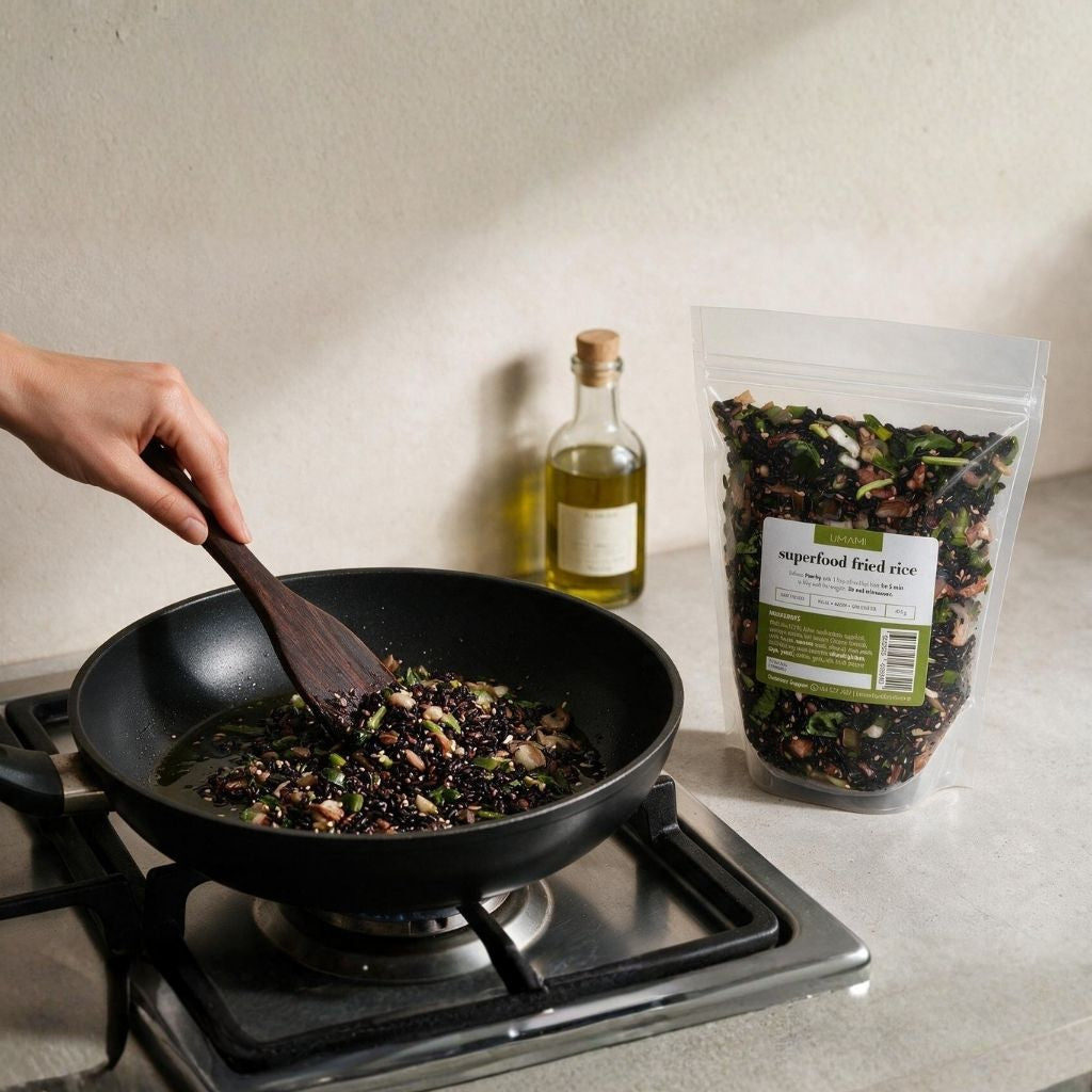 Superfood fried rice pan-fried in a black frying pan with a wooden spatula, olive oil and the 450g pouch beside the stove