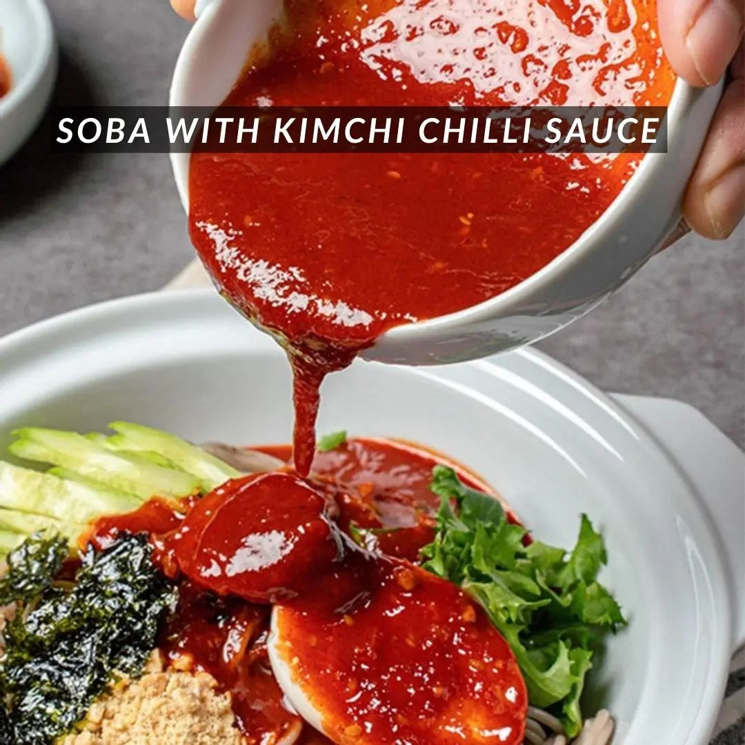 Pouring spicy kimchi sauce over noodles