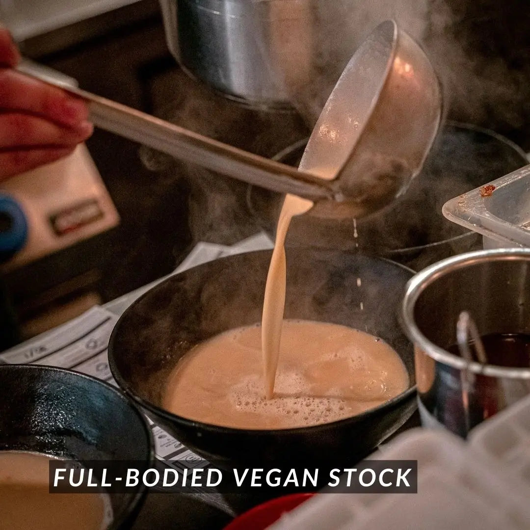 Ladling creamy vegan stock into a bowl