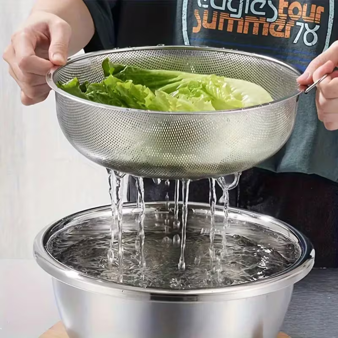 Lettuce rinsed in the stainless steel strainer, water draining into the matching bowl below