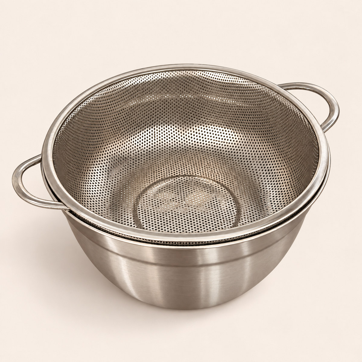 Stainless steel strainer sitting snug on its matching mixing bowl, 24cm set